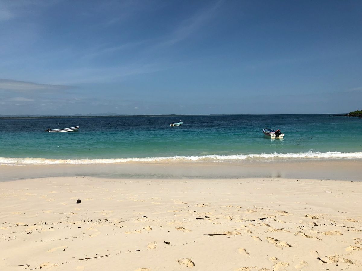 A white-sand beach with small boats offshore near Pedasí