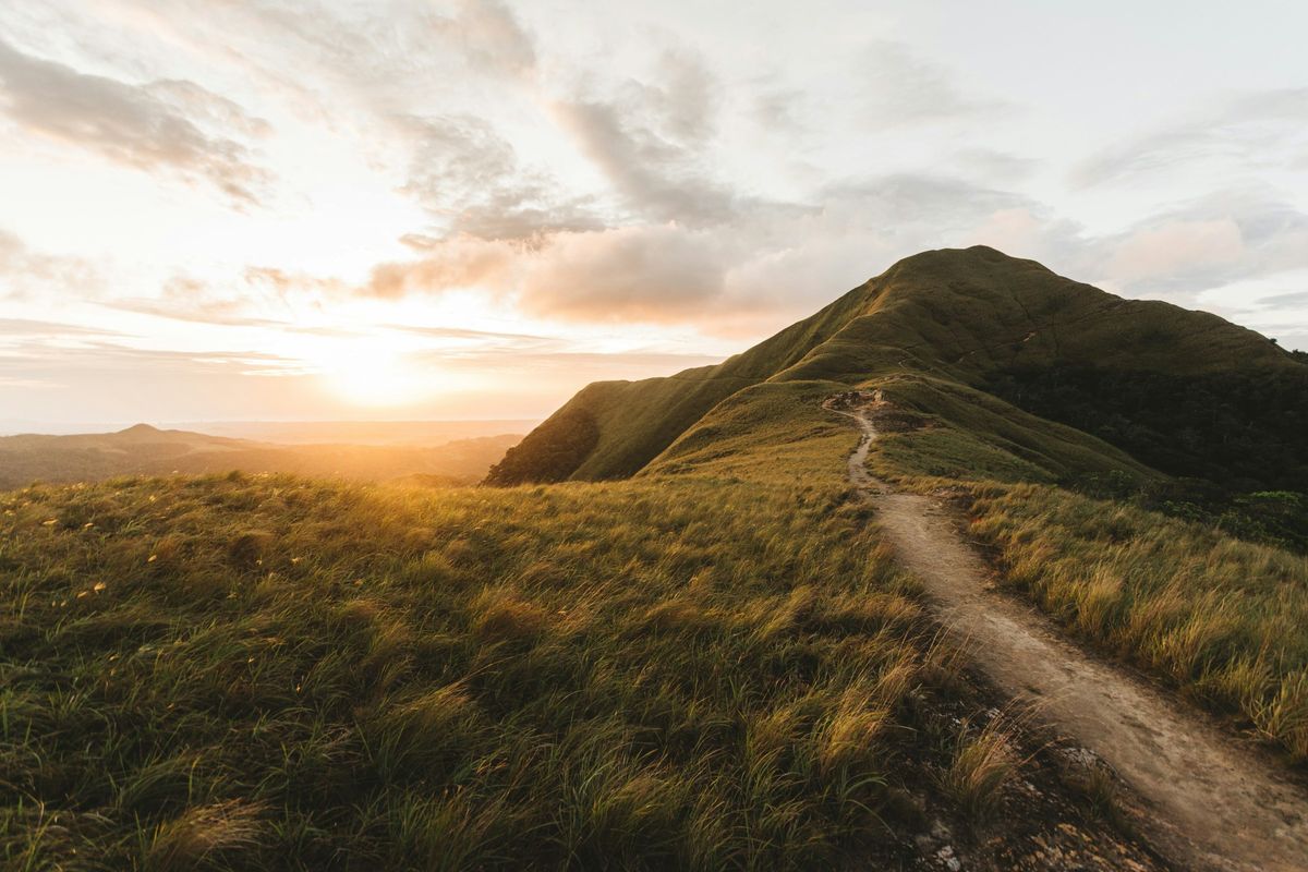 A path up a grassy hill at sunrise near El Valle de Antón