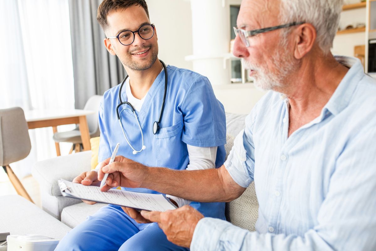 A nurse going through paperwork with an older man